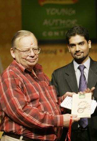 Indian author Ruskin Bond (L) is watched by Rupa &Co. publisher Kapish Mehra as he poses with a book of short stories entitled 'Post Box no. 99' in New Delhi 11 May 2005. ITC together with Rupa & Co. have launched 'Post Box no.99' a compilation of 12 award-winning short stories submitted by school children in the Classmate Young Author Contest (CYAC) Ruskin Bond