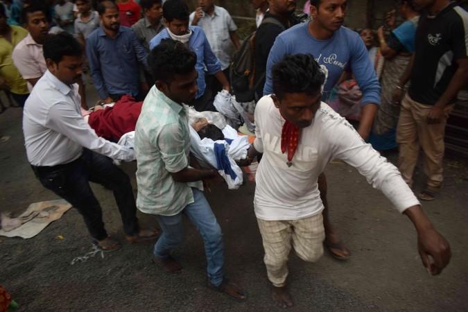 Indian local residents and rescue workers carry a survivor after a fire incident at the ESIC Kamgar hospital in Mumbai on December 17, 2018. - Six people were dead after a fire broke out in a five-storey hospital, local media reported. (Photo by - / AFP) fire incident at the ESIC Kamgar hospital