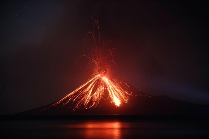 TOPSHOT - Lava streams down from Anak Krakatau (Child of Krakatoa) volcano during an eruption as seen from Rakata island in South Lampung on July 19, 2018. - An Indonesian volcano known as the 'child' of the legendary Krakatoa erupted on July 19, spewing a plume of ash high into the sky as molten lava streamed down from its summit. Anak Krakatau -- a small volcanic island that emerged from the ocean a half century after Krakatoa's deadly 1883 eruption -- has rumbled back to life in recent weeks, spitting flaming rocks and ash from its crater. (Photo by FERDI AWED / AFP) Lava streams down from Anak Krakatau (Child of Krakatoa) volcano