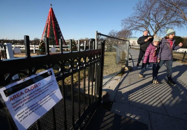 People walk past the National Christmas Tree that is currently closed to the public due to a partial shutdown of the federal government US govt shutdown
