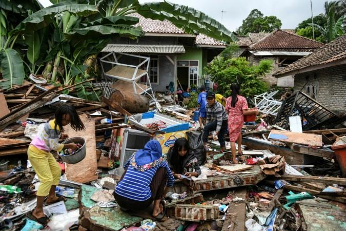 Residents search for belongings from their collapsed homes in Rajabasa in Lampung province on December 25, 2018, three days after a tsunami - caused by activity at a volcano known as the 'child' of Krakatoa - hit the west coast of Indonesia's Java island. - Desperately needed aid flowed into a stretch of Indonesia's tsunami-struck coastline on December 25, officials said, but aid workers warned that clean water and medicine supplies were dwindling as thousands crammed makeshift evacuation centres. (Photo by Mohd RASFAN / AFP) INDONESIA-DISASTER-TSUNAMI-VOLCANO