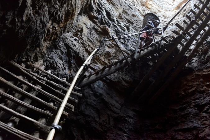 In this photograph taken on January 31, 2013, a miner slowly carries a heavy load of wet coal on a basket hundreds of feet up on wooden slats that brace the sides of a deep coal mine shaft near Rimbay village in the Indian northeastern state of Meghalaya. Thousands of private mines employ slim men and boys that will fit in thin holes branching out from deep shafts dug out from the ground in the East Jaintia Hills in Northeastern Indian state of Meghalaya. This state is the only state in India where coal mining is done privately by mine owners, who use cheap labour to supply the demand for this energy resource. Accidents and quiet burials are commonplace, with years of uncontrolled drilling making the rat-hole mines unstable and liable to collapse at any moment. After decades of unregulated mining, the state is due to enforce its first-ever mining policy later this year. meghalaya mines