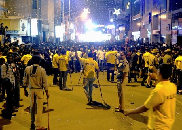 Indian police personnel holding 'lathi' sticks try to manage crowds during New Year's Eve celebrations in Bangalore on January 1, 2017. Indian police personnel holding 'lathi' sticks try to manage crowds during New Year's Eve celebrations in Bangalore on January 1, 2017.