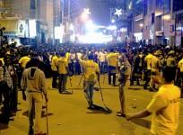 Indian police personnel holding 'lathi' sticks try to manage crowds during New Year's Eve celebrations in Bangalore on January 1, 2017.