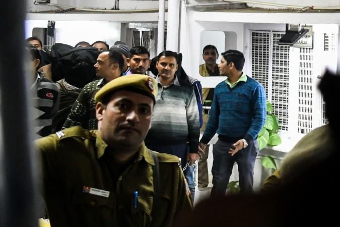 An agent of the National Investigation Agency (NIA) escorts suspected members (with masks) of a militant group 'Harkat ul Harb-e-Islam' outside the Patiala Court in New Delhi on December 27, 2018. Harkat ul Harb-e-Islam