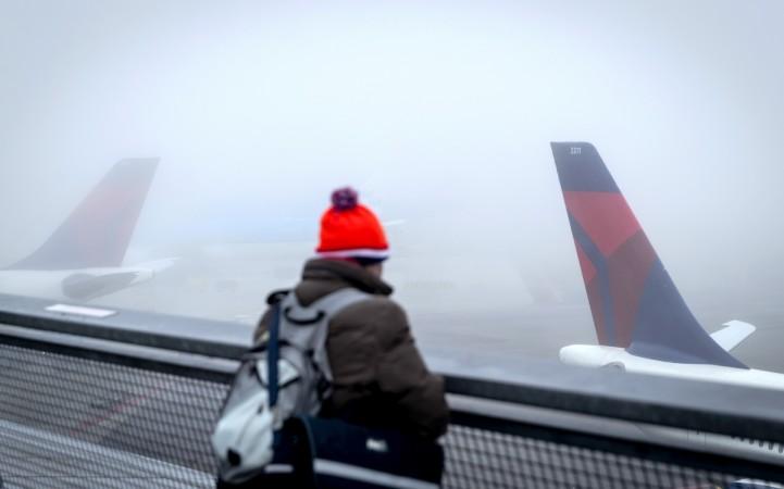 A person watches planes on the tarmac at the Schiphol Airport, The Netherlands, on December 28, 2016