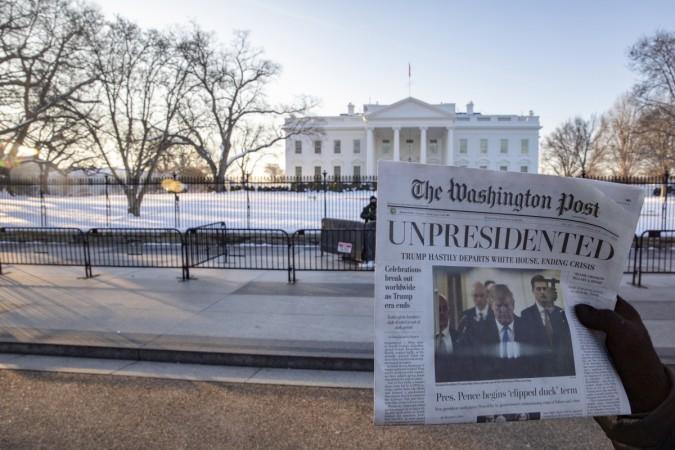 Volunteers distribute a lookalike 'special edition' of The Washington Post, date May 1, which predicts Trump leaving office after months of women-led protests on January 16, 2019 in Washington, DC Fake Washington Post