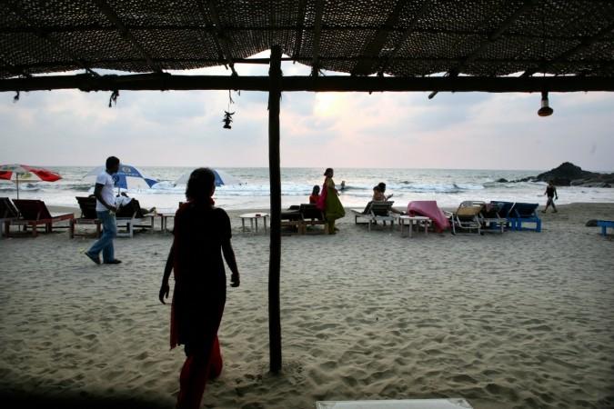 People walk along Vagator beach in Goa on March 17, 2008. Goa, a main touristic area accounts for nearly 12 percent of the four million tourists who visit India yearly. Goa