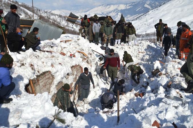 Local residents along with security personnel search the bodies of 10 missing policemen after a snow avalanche hit a police post at Qazigund Jawahar Tunnel in Kulgam district, some 90 km from Srinagar on February 8, 2019. - Three policemen were rescued on February 8 while five other bodies were recovered from an avalanche that buried 10 people in Indian-administered Kashmir following two days of heavy snowfall, police said. INDIA-KASHMIR-WEATHER-AVALANCHE