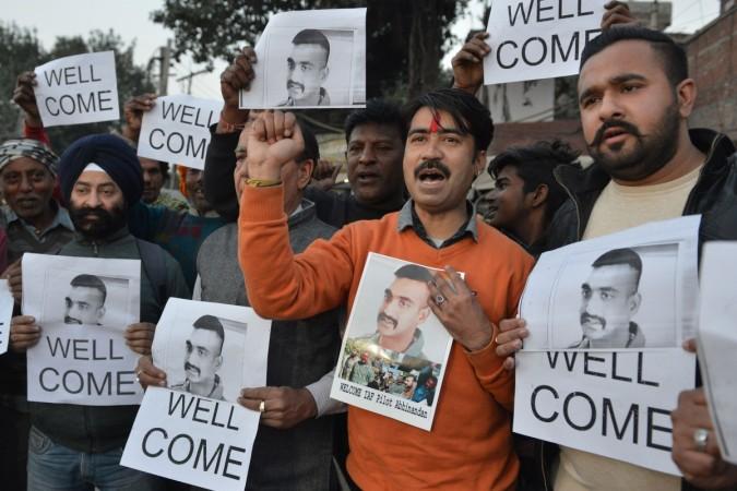 TOPSHOT - Indian people hold placards and photographs of Indian Air Force pilot Abhinandan Varthaman, as they celebrate the announcement of his soon release, in Amritsar on February 28, 2019. - Pakistan said on February 28 it will release a captured Indian pilot in a 'peace gesture', taking a step towards rapprochement as clashes between the nuclear-armed rivals ignited fears of a disastrous conflict. Indian people hold placards and photographs of Indian Air Force pilot Abhinandan Varthaman, as they celebrate the announcement of his soon release, in Amritsar on February 28, 2019