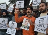 Indian people hold placards and photographs of Indian Air Force pilot Abhinandan Varthaman, as they celebrate the announcement of his soon release, in Amritsar on February 28, 2019