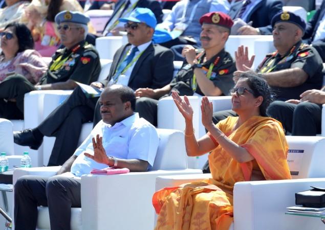 Nirmala Sitharaman applauds next to Karnataka Chief Minister HD Kumaraswamy during a flying display on the inaugural day of the five-day Aero India 2019 at Yelahanka Air Force station. Indian Minister for defence Nirmala Sitharaman (R) applauds next to Karnataka Chief Minister H.D. Kumaraswamy (L) as they watch aircrafts perform aerobatics during a flying display