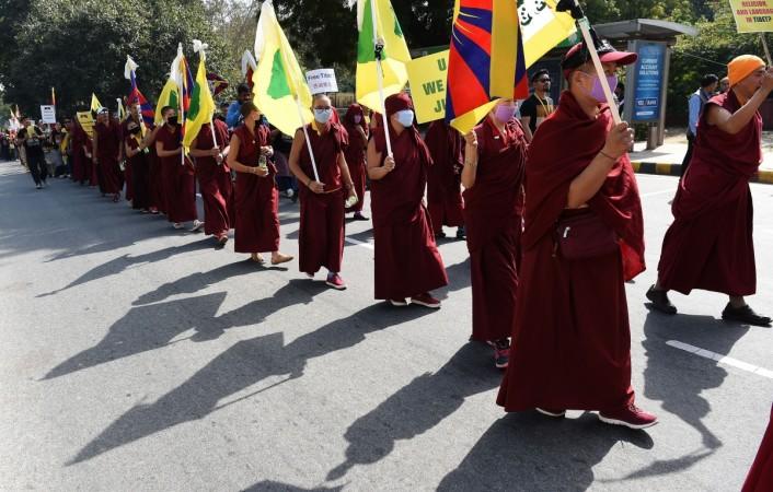 Tibetan exile activists and monks hold Tibetan flags Tibetan exile activists and monks hold Tibetan flags