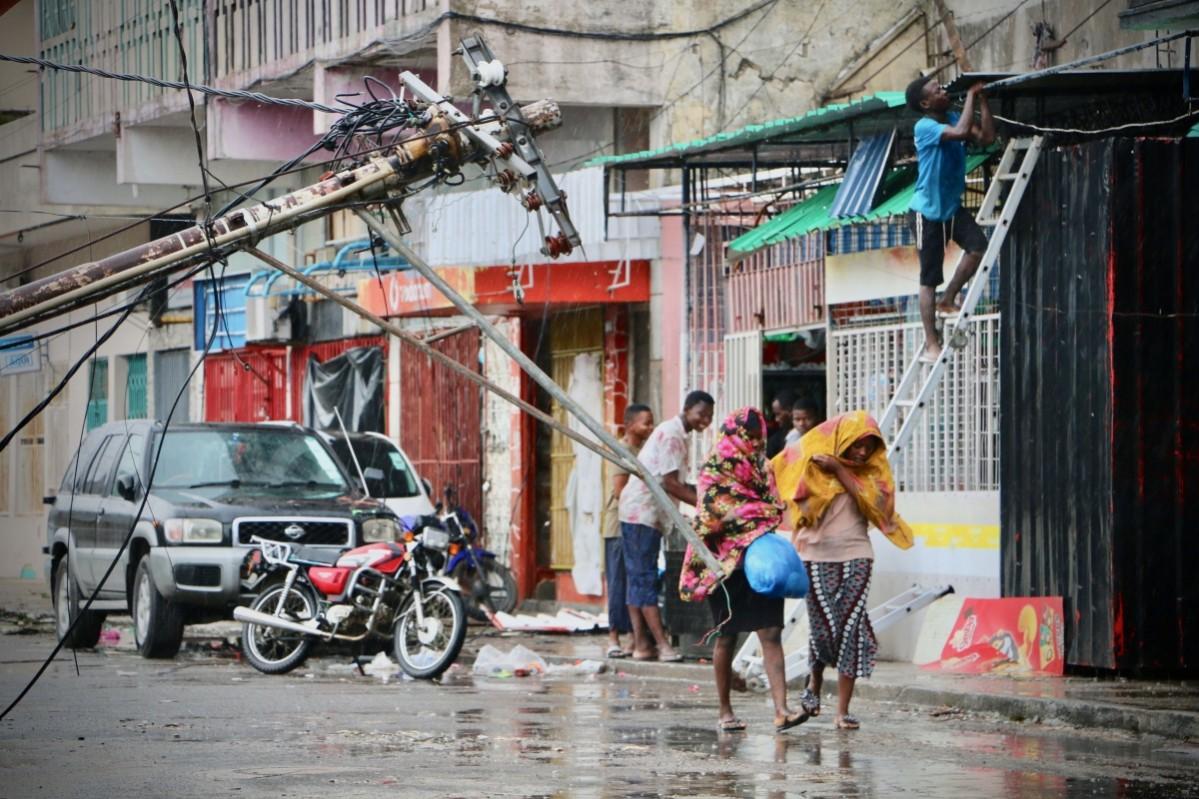 Residents are seen protecting themselves by the rain in the aftermath of the passage of the cyclone Idai in Beira, Mozambique, on March 17, 2019 Mozambique