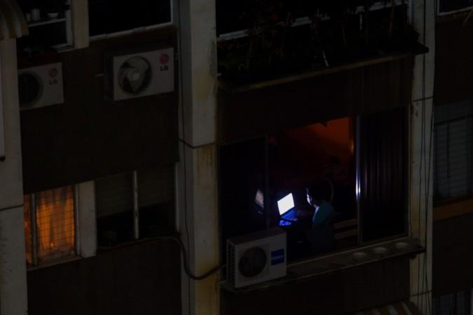 A man uses a laptop during a power outage in Caracas, Venezuela, on March 26, 2019, two weeks after a similar outage caused deaths and chaos. - Venezuela decreed a 24-hour holiday Tuesday to cope with a new near-nationwide blackout that the government alleged was caused by an 'attack' targeting its main hydroelectric plant. A man uses a laptop during a power outage in Caracas, Venezuela, on March 26, 2019