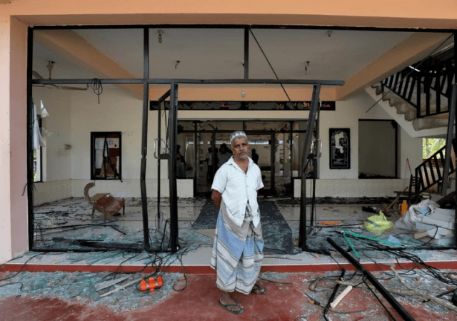 A Muslim man stands in front of the Abbraar Masjid mosque after a mob attack in Kiniyama, Sri Lanka on Monday. Sri Lanka