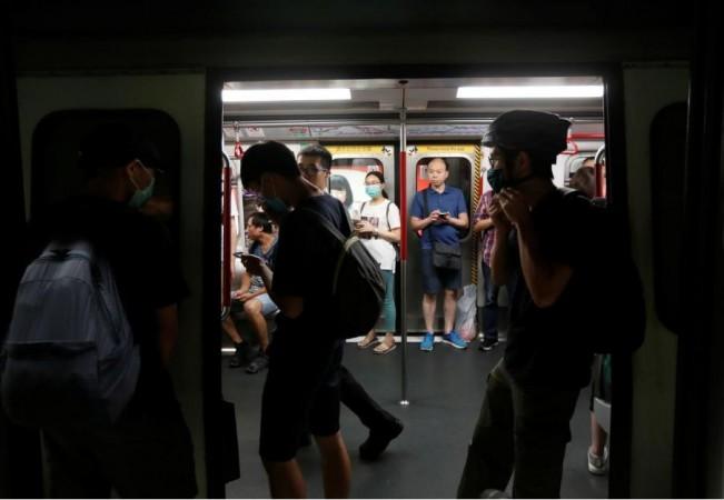 Protestors stand preventing Mass Transit Railway's (MTR) subway train from leaving Fortress Hill station in Hong Kong on August 5, 2019. Hong Kong protests