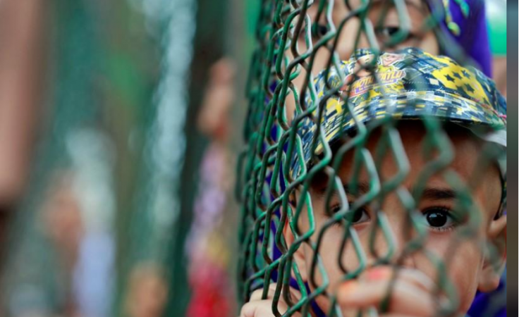 Kashmiri child looks from behind a fence at a protest site after Friday prayers during restrictions after the Indian government scrapped the special constitutional status for Kashmir, in Srinagar, August 16, 2019. Kashmiri child
