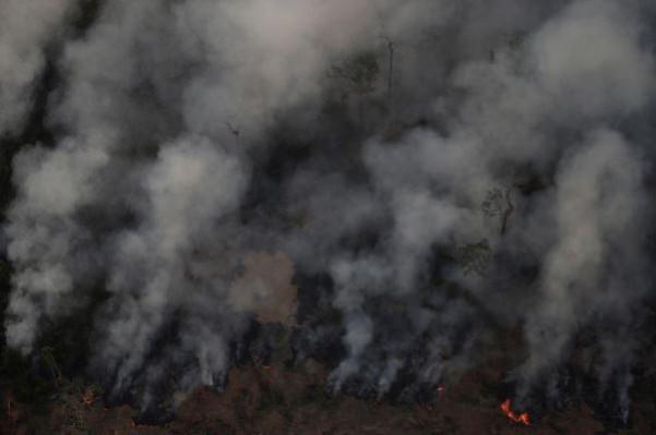 The smoke from the resulting fires hangs at the horizon like a fog. Amazon rainforest