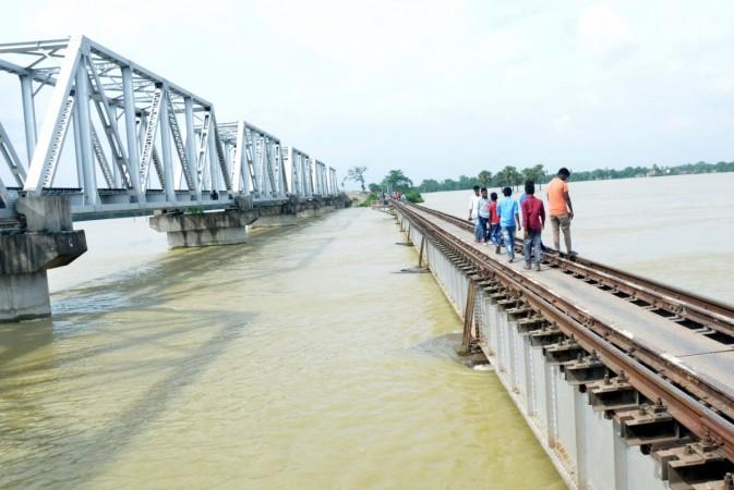 People walk across a railway bridge over the swollen Bagmati river. Bihar flood