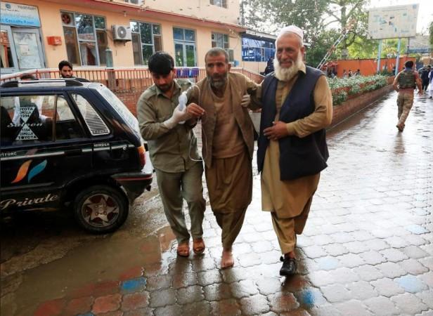 Men carry an injured person to a hospital after a bomb blast at a mosque, in Jalalabad, Afghanistan October 18, 2019. Afghan blast