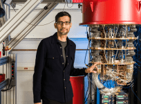 Sundar Pichai posing next to Google's quantum computer
