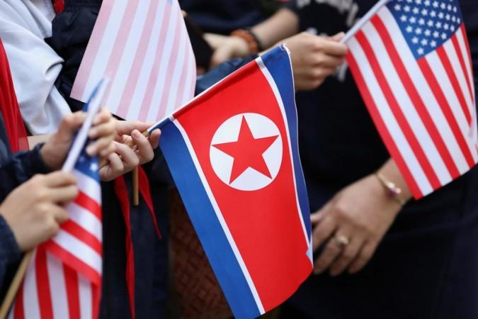 Bystanders holding North Korea and US flags. North Korea US