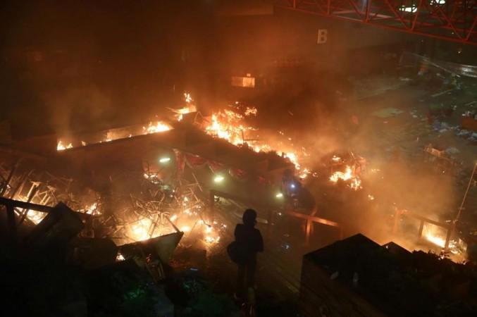 A protester looks at fire at Hong Kong Polytechnic University (PolyU) during an anti-government protest in Hong Kong, China November 18, 2019 Hong Kong university violence