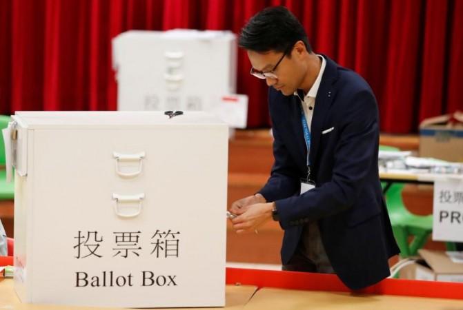 A polling officer opens a ballot box to count the votes of the Hong Kong council elections, in a polling booth in Hong Kong, China November 24, 2019. Hong Kong elections