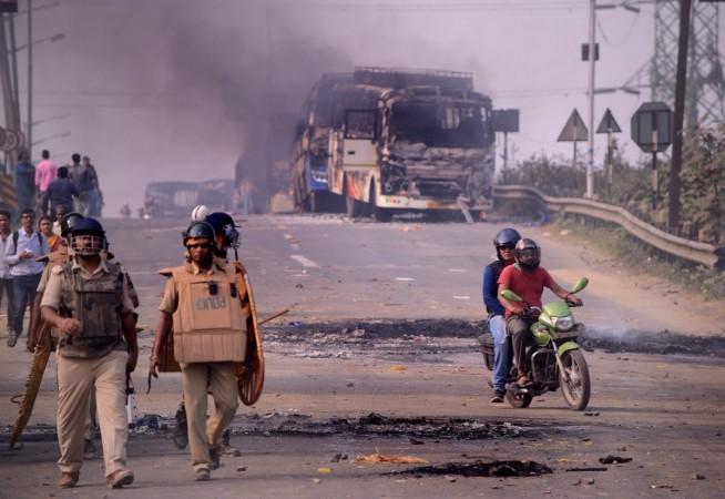Howrah: Police personnel patrol a street after violence broke out as angry protesters burnt vehicles during a demonstration against the Citizenship Amendment Act (CAA) 2019, in West Bengal's Howrah on Dec 14, 2019. Violent protests against the new citizenship law spread to more areas in West Bengal on Saturday as mobs torched buses, set afire railway property and blockaded road and rail disrupting train and vehicular movement. howrah