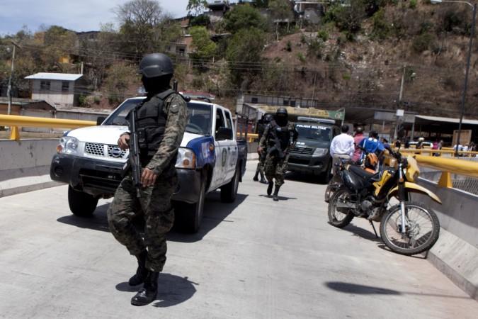 Honduran authorities inspect the site of the homicide of three women, in Tegucigalpa, Honduras. Honduran authorities