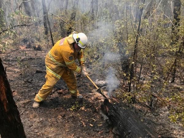 A volunteer from the New South Wales Rural Fire Service works to extinguish spot fires following back burning operations in Mount Hay, Australia. Australia bush fire