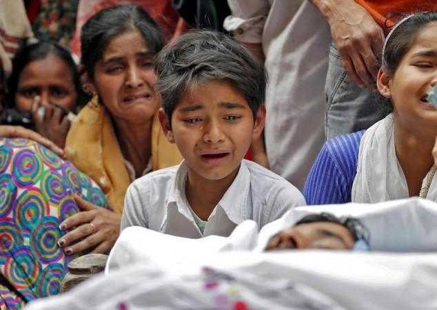 People mourn next to the body of Muddasir Khan, who was wounded on Tuesday in a clash between people demonstrating for and against a new citizenship law, after he succumbed to his injuries, in a riot affected area in New Delhi, February 27, 2020. Delhi Riots