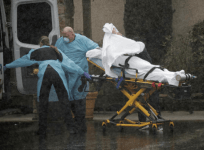 Medics transport a patient through heavy rain into an ambulance at Life Care Center of Kirkland, the long-term care facility linked to several confirmed coronavirus cases in the state, in Kirkland, Washington, U.S. March 7, 2020. REUTERS/David Ryder