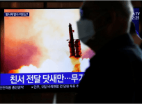 A man walks past a TV broadcasting file footage for a news report on North Korea firing an unidentified projectile, in Seoul, South Korea, March 9, 2020. REUTERS/Heo Ran