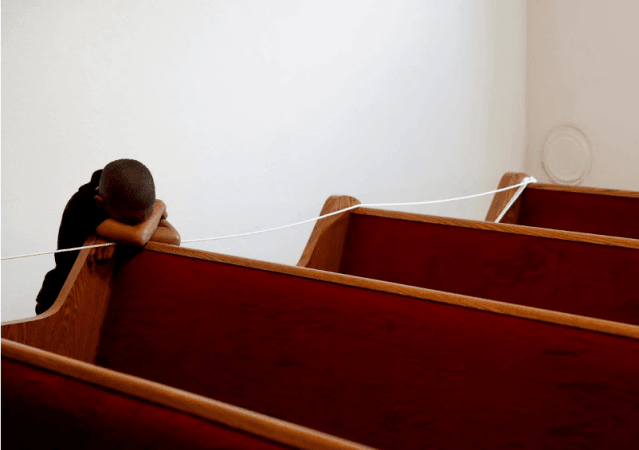 Zechariah Payton, 5, puts his head down on an empty pew, on the third day of California Governor Gavin Newsom's implemented statewide palm sunday quarantine
