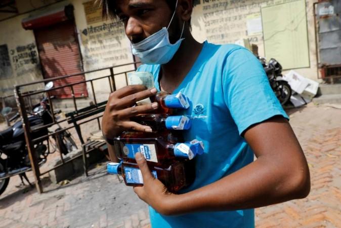 FILE PHOTO: A man carries liquor bottles after buying them at a wine shop during an extended nationwide lockdown to slow the spread of the coronavirus disease (COVID-19), in New Delhi, India, May 4, 2020. REUTERS/Adnan Abidi/File Photo FILE PHOTO: A man carries liquor bottles after buying them at a wine shop during an extended nationwide lockdown to slow the spread of the coronavirus disease (COVID-19), in New Delhi, India, May 4, 2020. REUTERS/Adnan Abidi/File Photo