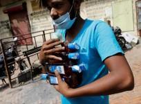 FILE PHOTO: A man carries liquor bottles after buying them at a wine shop during an extended nationwide lockdown to slow the spread of the coronavirus disease (COVID-19), in New Delhi, India, May 4, 2020. REUTERS/Adnan Abidi/File Photo
