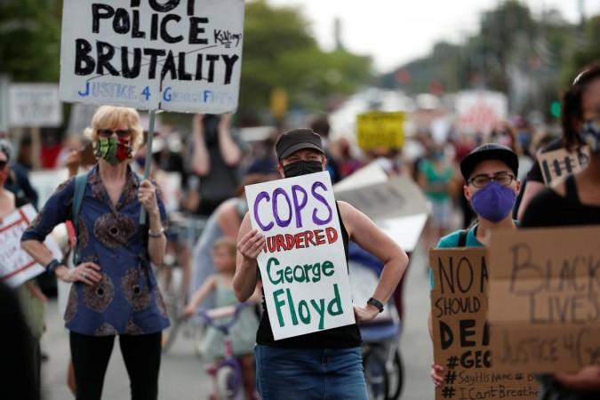 Protesters gather at the scene where George Floyd, an unarmed black man, was pinned down by a police officer kneeling on his neck before later dying in hospital in Minneapolis, Minnesota, U.S. May 26, 2020. REUTERS/Eric Miller