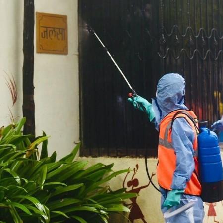 A BMC official sprays disinfectants to sanitize Amitabh Bachchan's residence Jalsa after the megastar and his son Abhishek Bachchan were tested positive for coronavirus with mild symptoms. Amitabh Bachchan, Jalsa