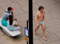 A man wearing a surgical mask as G-string walks past a woman, as the spread of the coronavirus disease (COVID-19) continues, on Oxford Street in London, Britain July 24, 2020. REUTERS/Simon Dawson