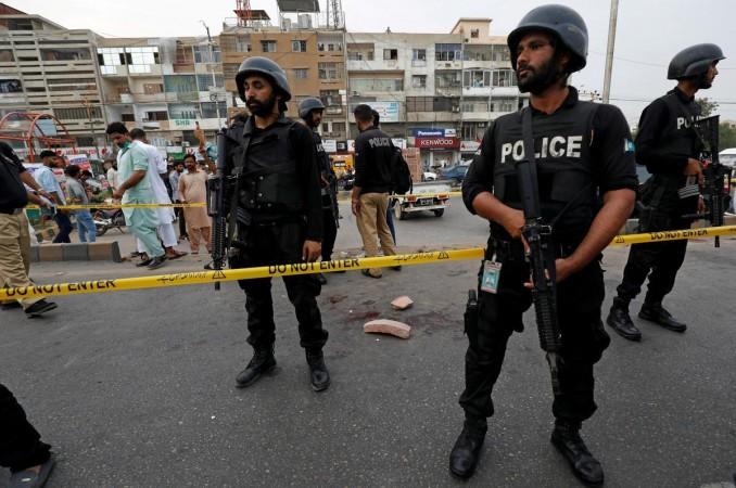 Police officers guard at the cordoned site after, according to police a grenade attack was carried out on a rally by the supporters of religious and political party Jamaat-e-Islami (JI) to mark the Pakistan
