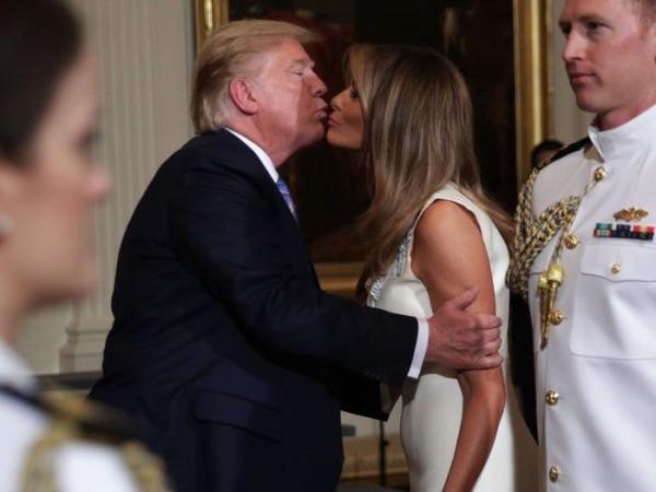In a photo taken in May, 2019, President Donald Trump kisses first lady Melania Trump during an event at the White House. Trump Melania