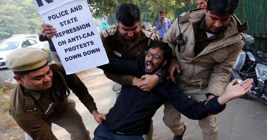 Police detain a demonstrator outside the Assam Bhawan during a protest against the Citizenship Amendment Act in New Delhi on December 23. | Reuters CAA