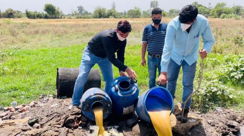 Sleuths of Excise Department destroying illicit liquor