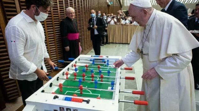 Pope Francis playing a game of foosball Pope Francis