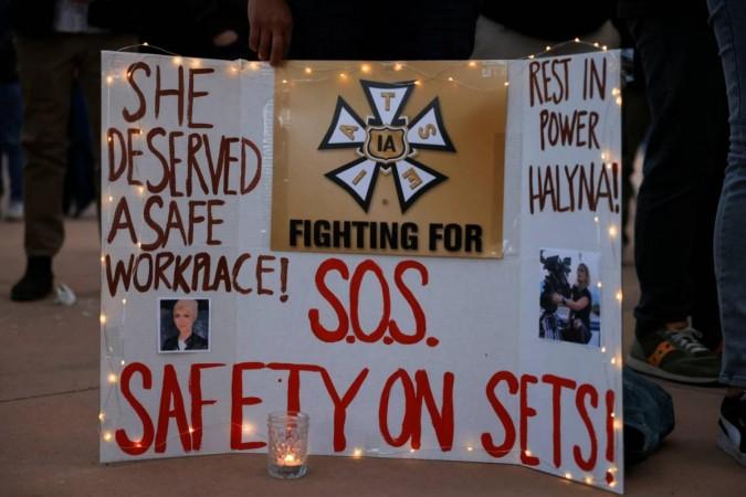 A woman displays a sign calling for workplace safety at a vigil for cinematographer Halyna Hutchins A woman displays a sign calling for workplace safety at a vigil for cinematographer Halyna Hutchins, who died after being accidentally shot by Alec Baldwin on the set of his movie 'Rust'.