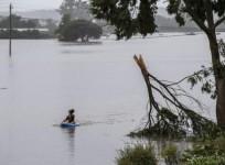 A child paddles a boat in flood water in Richmond of New South Wales, Australia