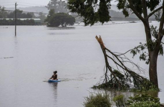A child paddles a boat in flood water in Richmond of New South Wales, Australia. A child paddles a boat in flood water in Richmond of New South Wales, Australia