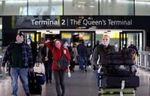 A passenger walks past a public health notice in Heathrow Airport in London, Britain.
